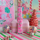Peppermint Cutie Apple Watch band assembled and standing upright beside a red and white peppermint tree and glitter ornaments