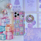 No Peeking, Darling MagSafe grip ring lying beside the matching pastel present iPhone case and a stack of wrapped gifts