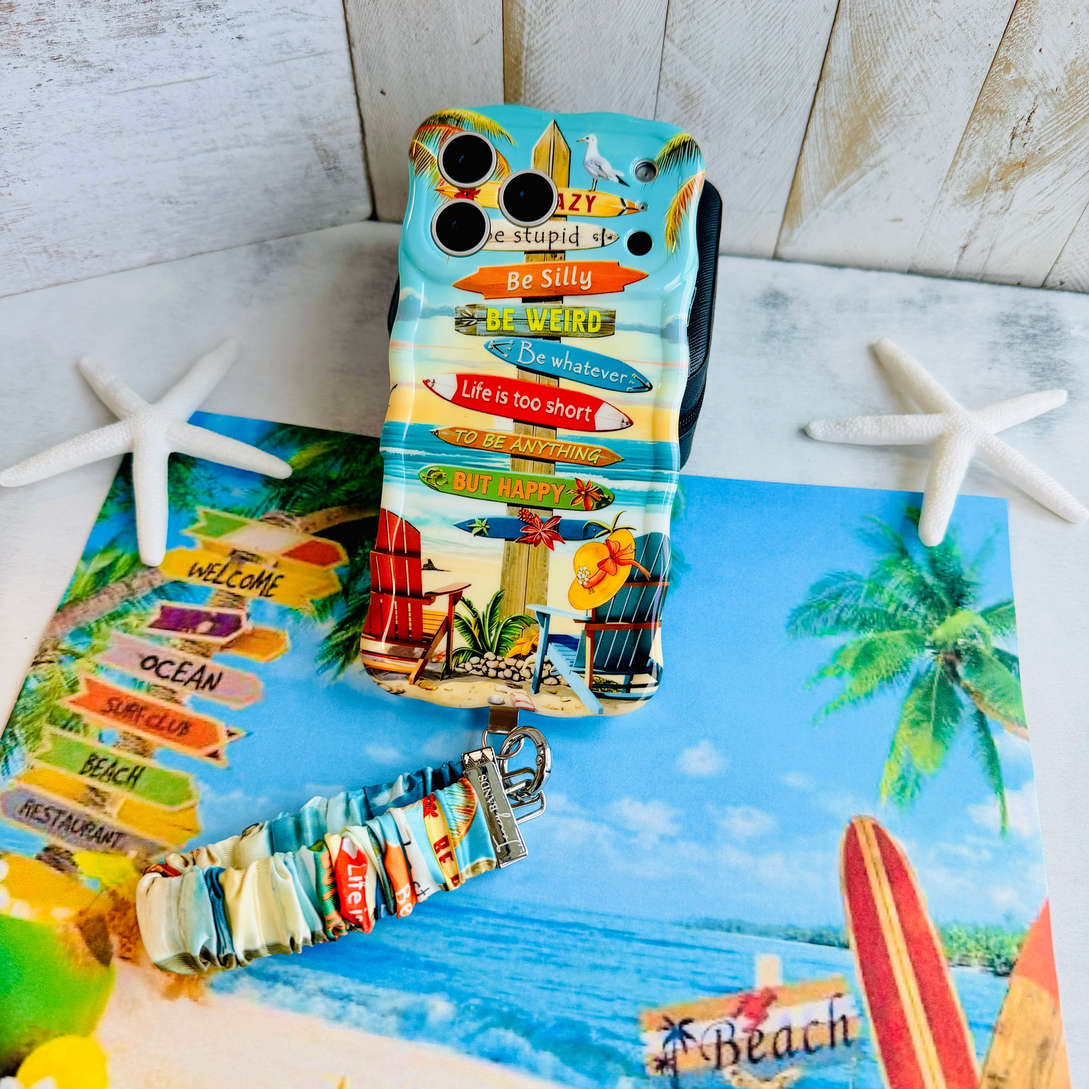 Seaside State Of Mind scrunchie phone wrist strap clipped to the matching Seaside State Of Mind Wavy Luxe iPhone case