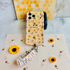 Bee Happy scrunchie phone wrist strap clipped to the matching Bee Happy Wavy Luxe iPhone case