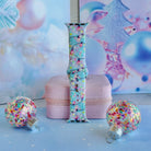 Twinkle All The Way Apple Watch band buckled and standing on a pink jewelry box between confetti glitter ornaments
