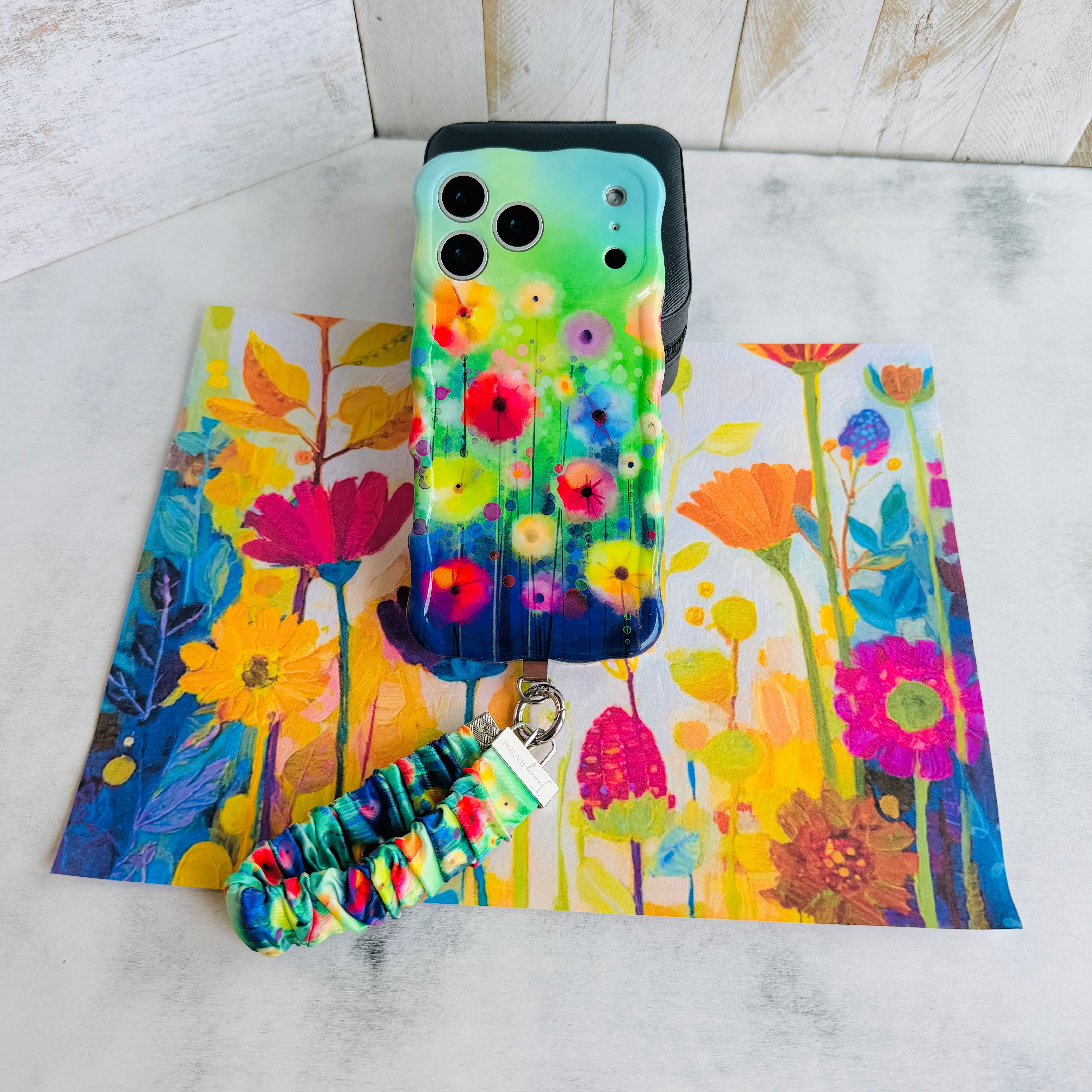 Petal Princess scrunchie phone wrist strap clipped to the matching Petal Princess Wavy Luxe iPhone case