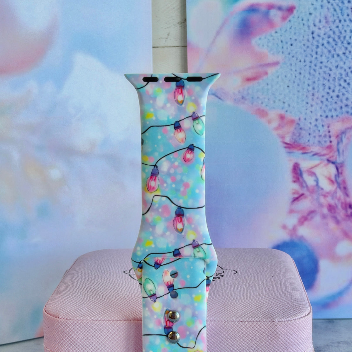 Close-up of a single Twinkle All The Way Apple Watch band strap, pastel Christmas bulbs on aqua