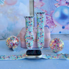 Twinkle All The Way Apple Watch band shown on an Apple Watch and as two straps on a pink jewelry box, Christmas lights on aqua