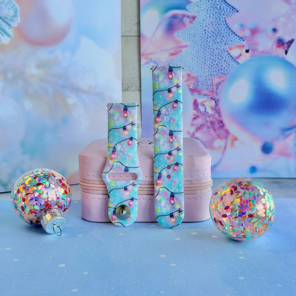 Both straps of the Twinkle All The Way silicone Samsung Galaxy Watch band on a pink jewelry box with confetti ornaments