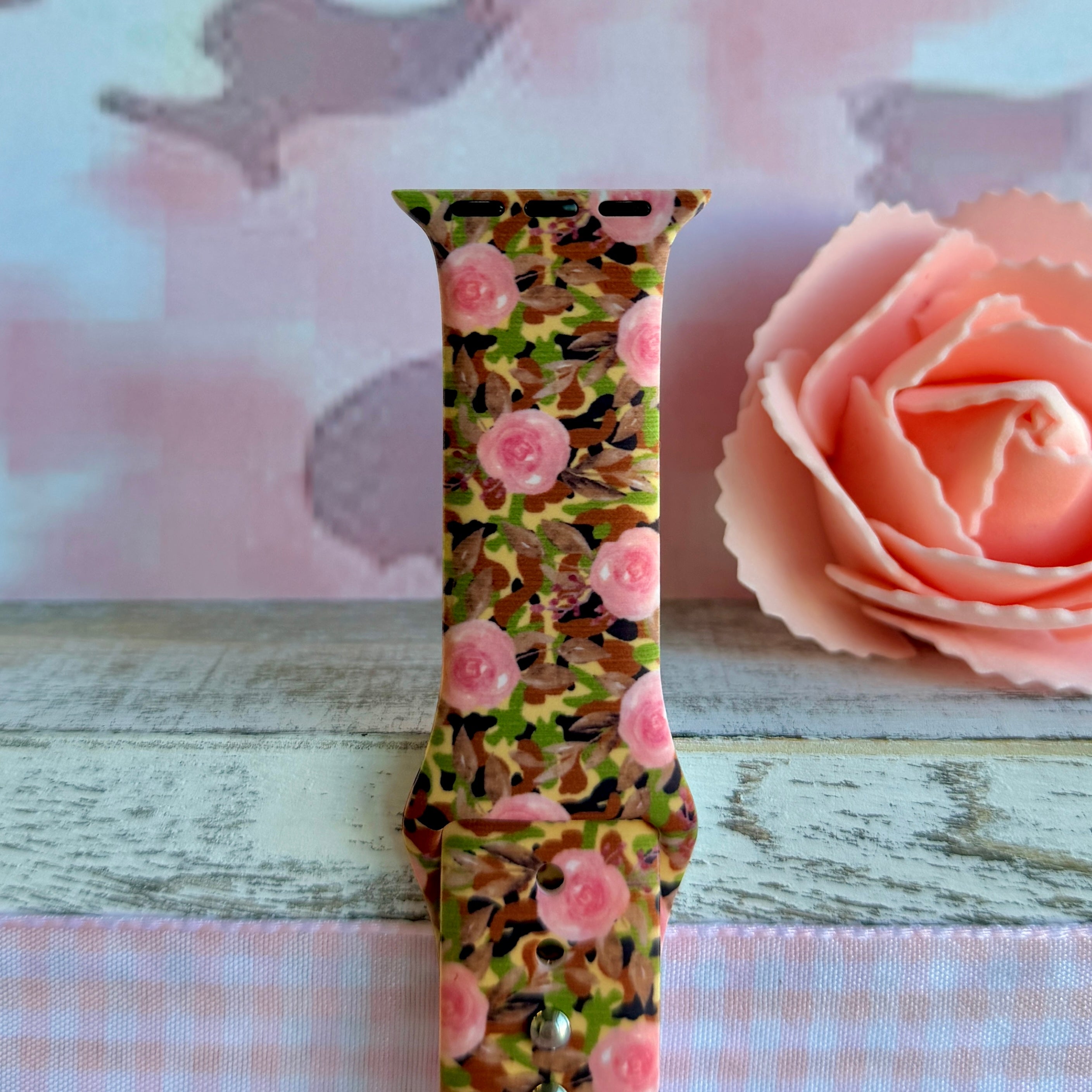 Sweet & Savage Apple Watch band with pink watercolor roses over camo print pattern with peach rose decoration
