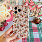 Hand holding the Boot Scootin' Christmas Wavy Luxe MagSafe iPhone case, cowboy boots, hats and lasso Christmas lettering on cream, beside a gold star and cowboy boot art