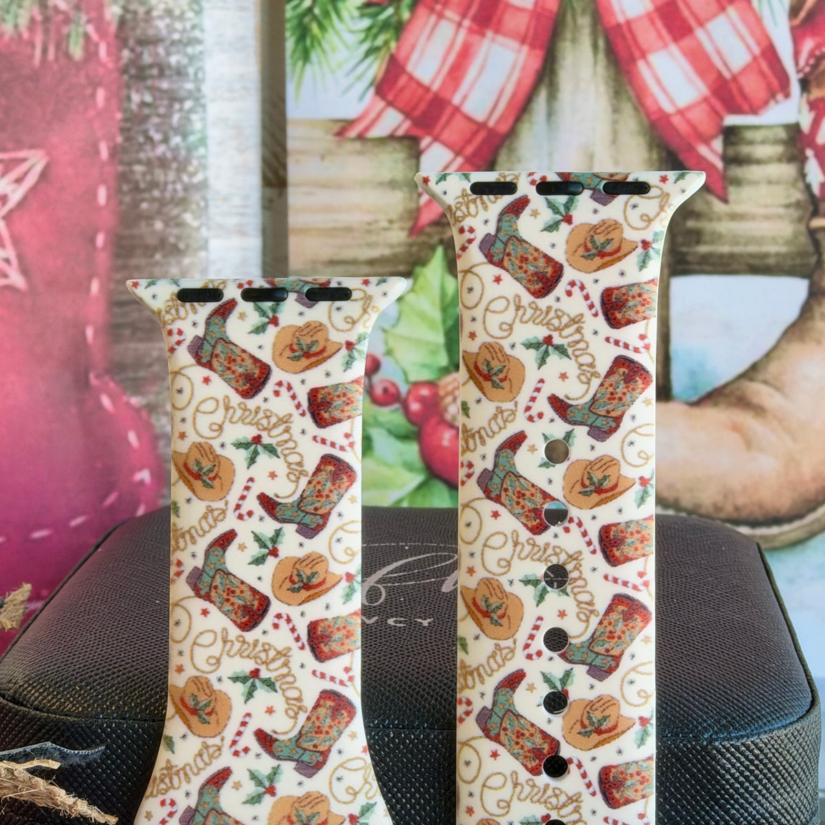 Close-up of both Boot Scootin' Christmas Apple Watch band straps with cowboy boots, tan hats, candy canes and lasso Christmas lettering