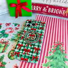 Plaid Tidings & Bows Hold It Fancy MagSafe grip ring snapped onto the matching gingham bow iPhone case, beside a green gift box with a red bow
