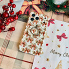Deck Yourself in Bows & Holly Hold It Fancy MagSafe grip ring snapped onto the matching bow-print iPhone case, on cream plaid with red berries