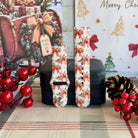 Both straps of the Deck Yourself in Bows & Holly silicone Samsung Galaxy Watch band on a black jewelry box with red berries and a pinecone