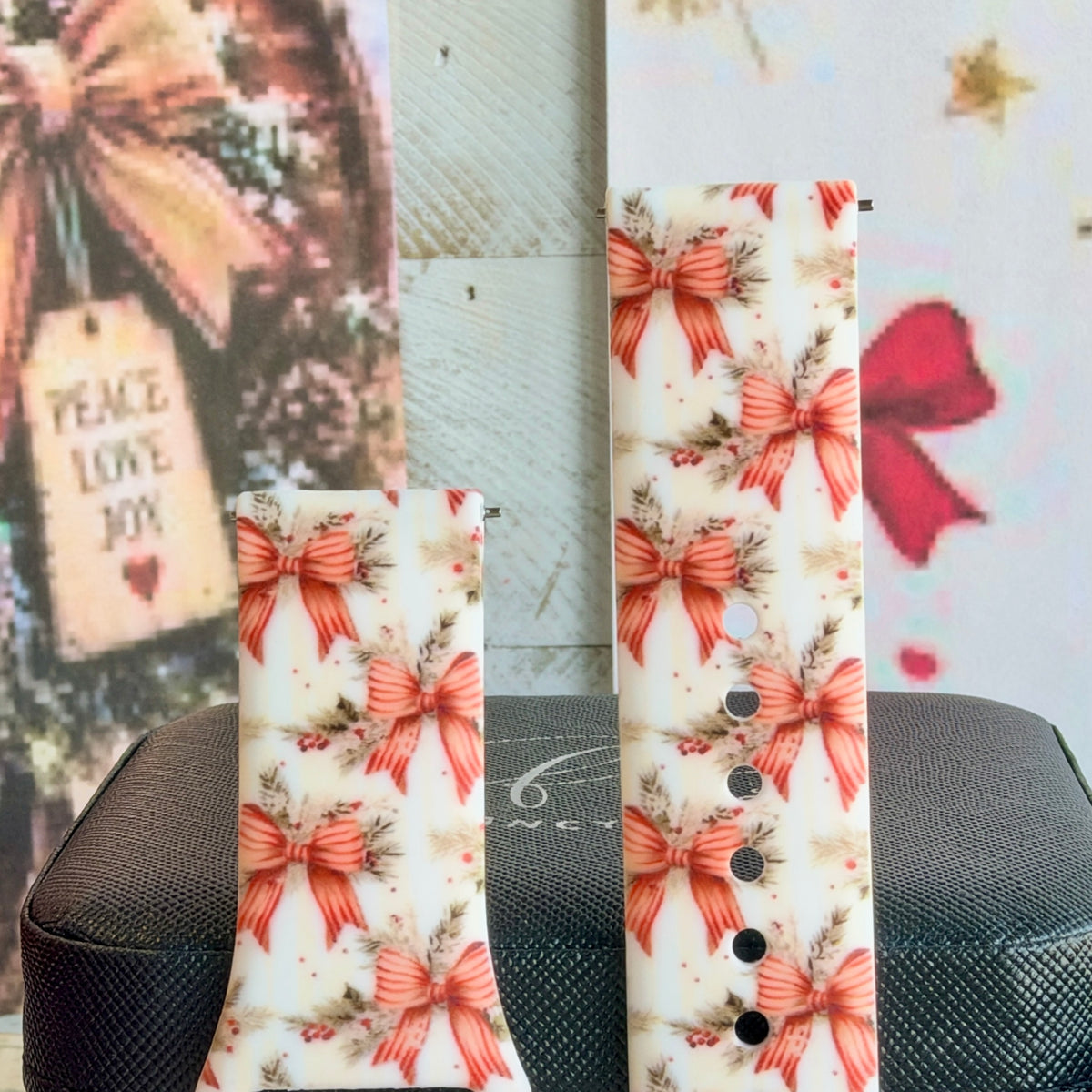 Close-up of both Deck Yourself in Bows & Holly Samsung Galaxy Watch band straps with striped red ribbon bows and holly on ivory