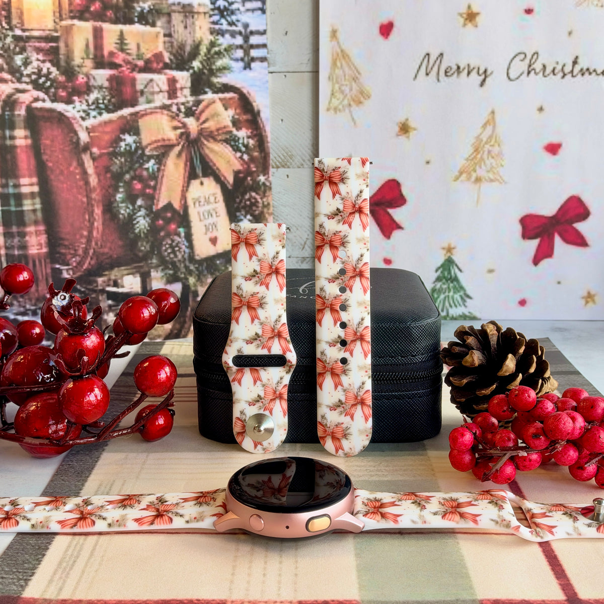 Deck Yourself in Bows & Holly Samsung Galaxy Watch band on a rose gold Galaxy Watch, with both straps on a black jewelry box