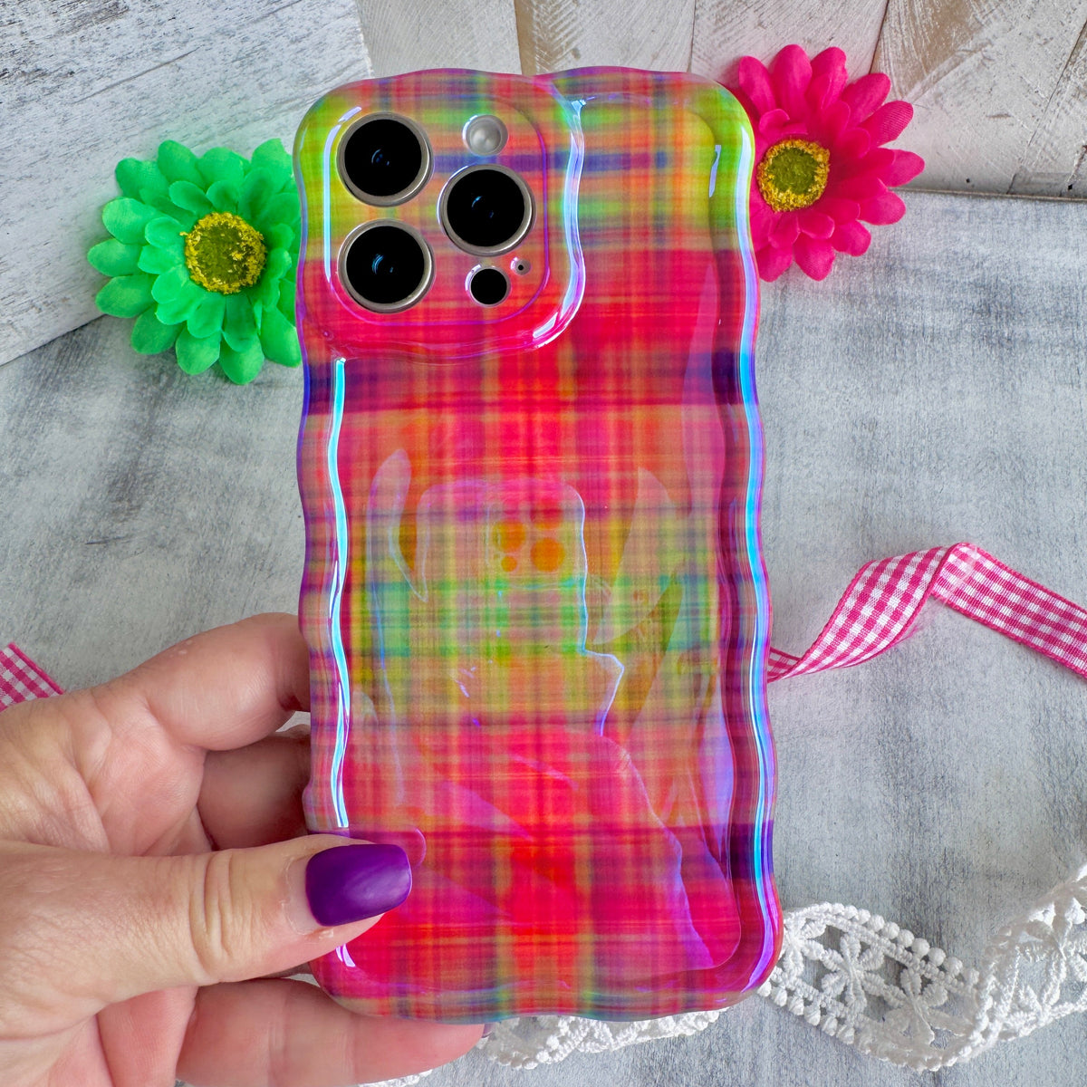 Hand holding the Hazy Tartan Wavy Luxe MagSafe iPhone case, soft-focus rainbow plaid in pink, lime and marigold