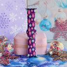 Single Just One More Ornament Apple Watch band strap standing on a pink jewelry box with aqua and pink glass ornaments behind