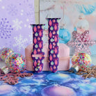 Just One More Ornament Apple Watch band buckled and standing on a pink jewelry box between confetti ornaments and pink glitter snowflakes