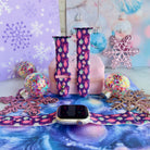 Just One More Ornament Apple Watch band shown on an Apple Watch and as two straps on a pink jewelry box, pink and aqua ornaments on plum