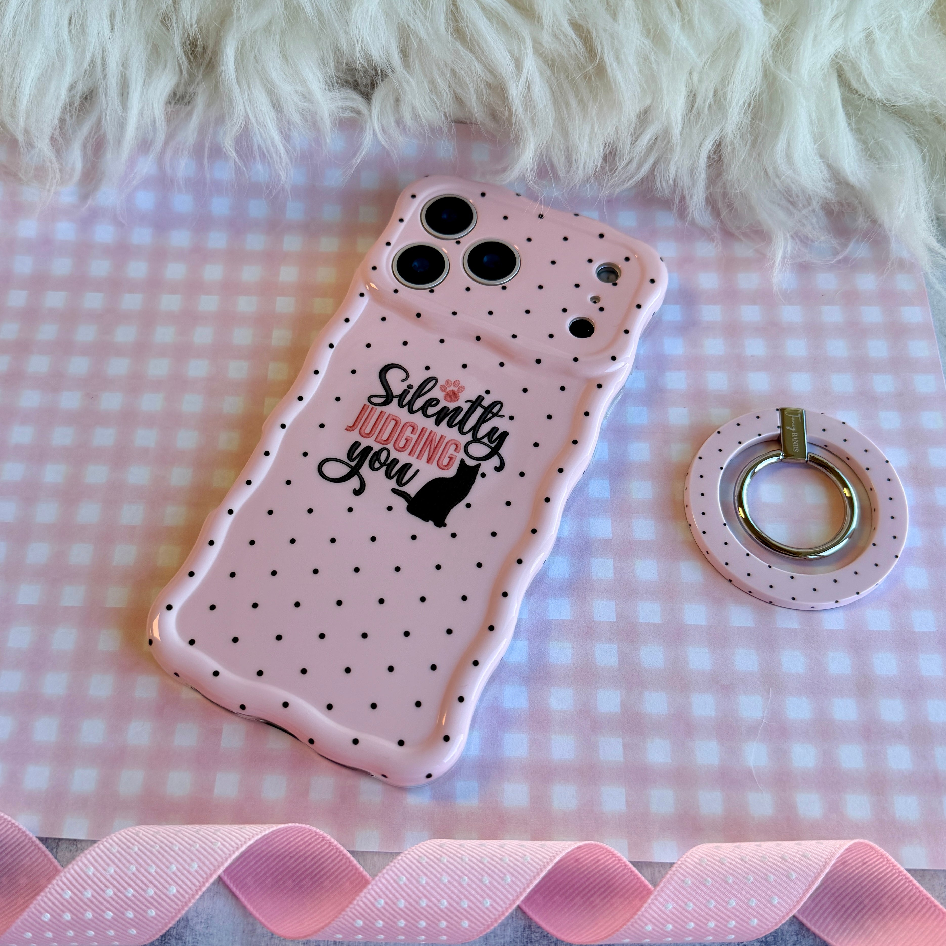 Light pink wavy iPhone case with black polka dots featuring a black cat silhouette and the text Silently Judging You.