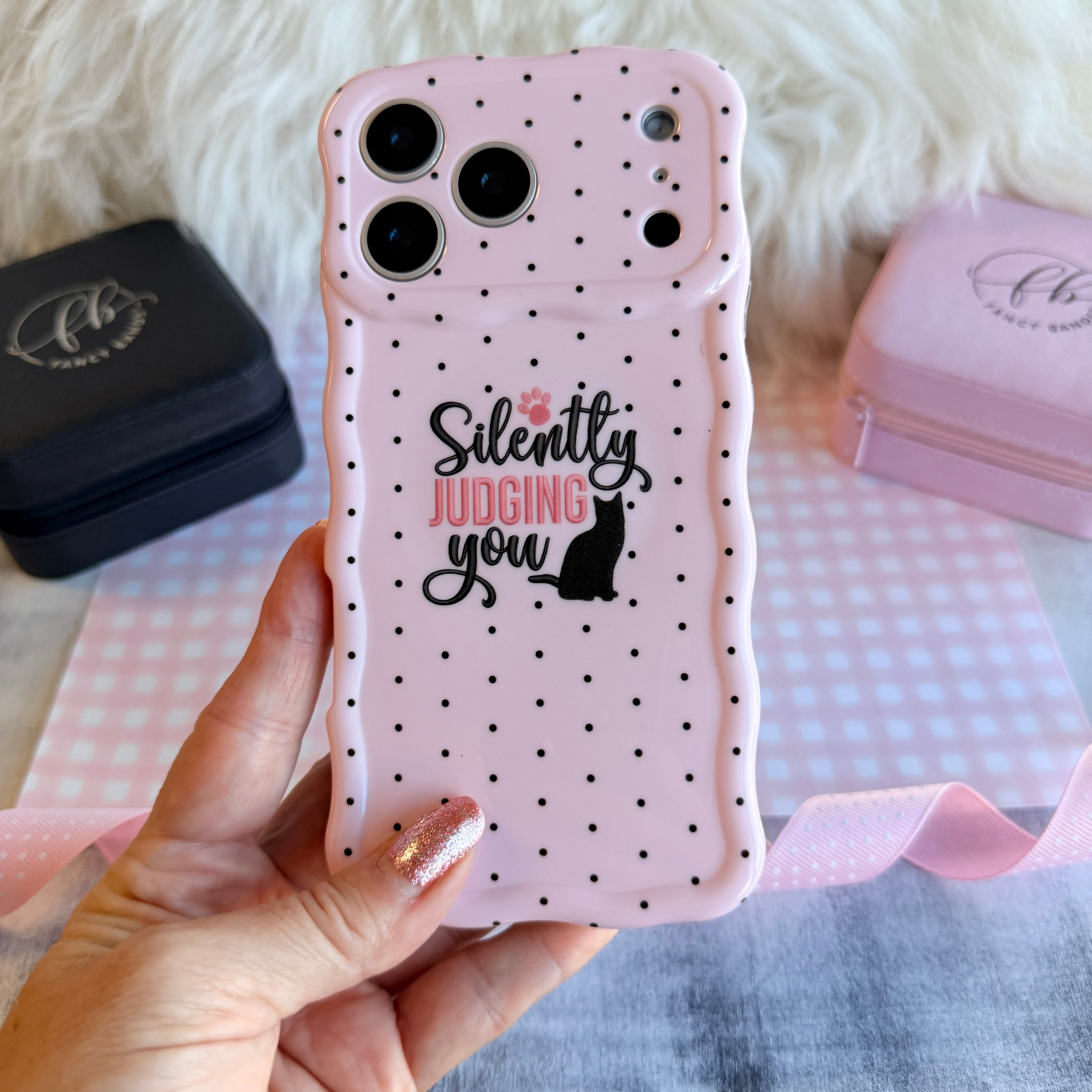 Light pink wavy iPhone case with black polka dots featuring a black cat silhouette and the text Silently Judging You.