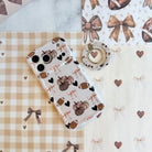 Game Day Darling Hold It Fancy MagSafe grip ring with a cream coquette print of footballs, leopard pumpkins, bows and hearts from Fancy Bands