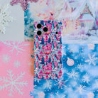 Sugarplum Square iPhone case lying on icy blue snowflake paper and pink paper beside white and pink glitter snowflakes