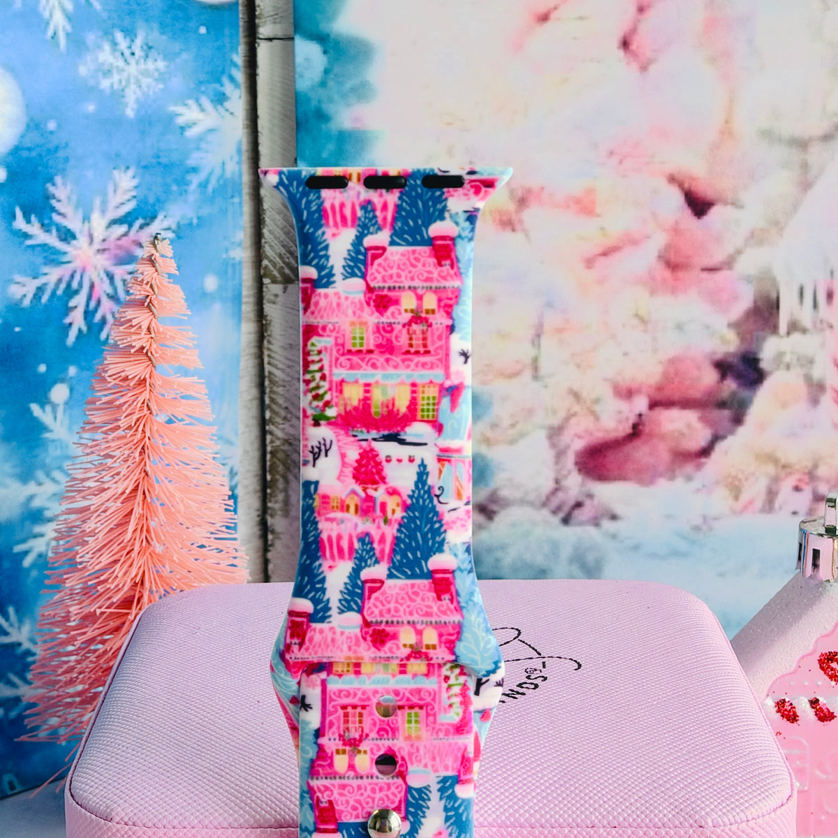 Close-up of a single Sugarplum Square Apple Watch band strap, pink Christmas village print