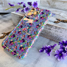 Lavender wavy iPhone case featuring colorful hummingbirds, purple flowers, and the quote Find Your Joy In The Little Things.
