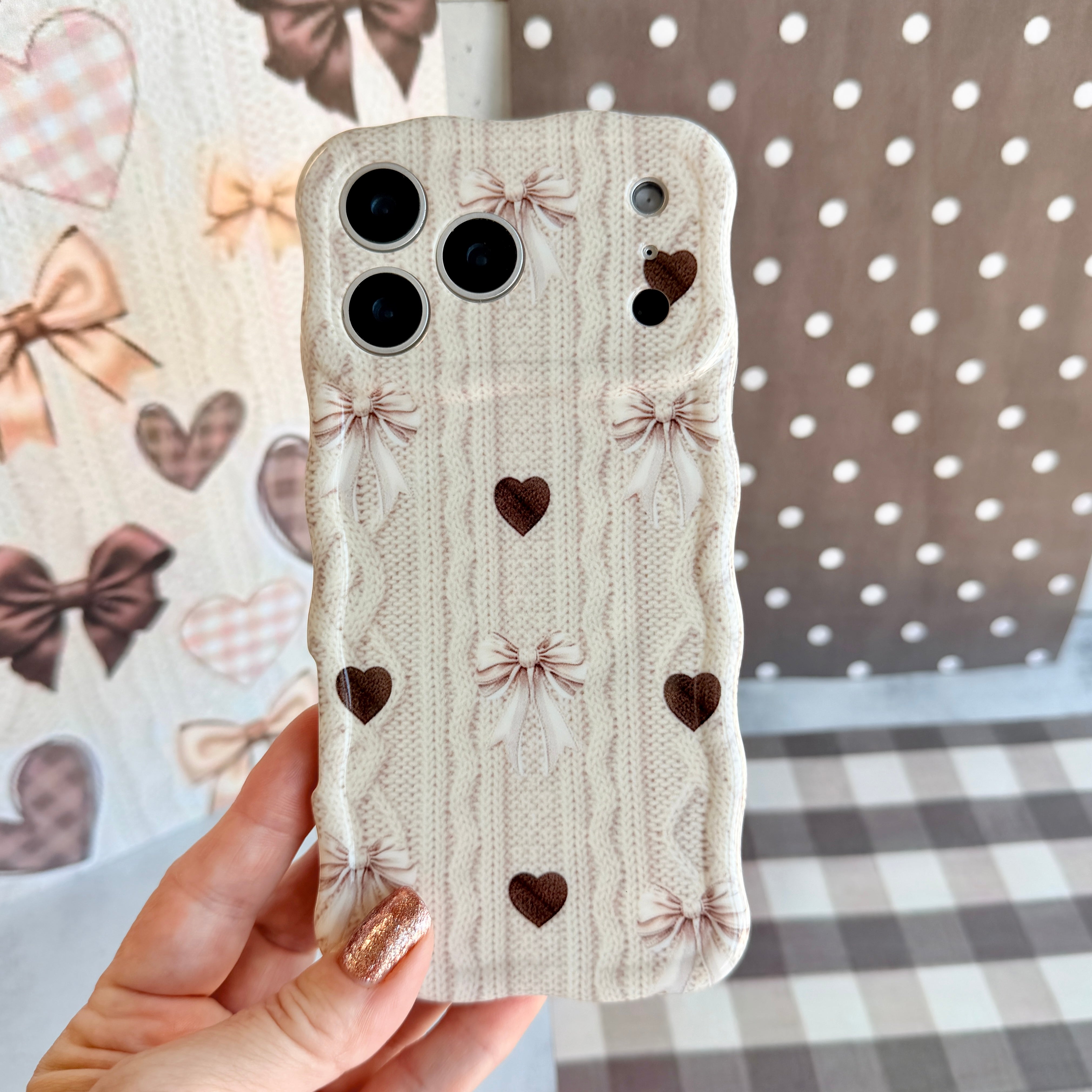 Sweater Weather Sweetheart Wavy Luxe MagSafe iPhone case featured hero shot with cream cable-knit print, taupe bows, and rich brown hearts from Fancy Bands.