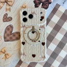 Sweater Weather Sweetheart MagSafe grip ring shown attached to the back of an iPhone with matching cream knit, bow, and heart print styling.