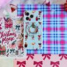Holiday Spirits, Please? MagSafe grip ring snapped onto the matching cocktail print iPhone case, on pink and blue plaid
