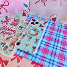 Holiday Spirits, Please? Hold It Fancy MagSafe grip ring snapped onto the matching cocktail print iPhone case, on pink and blue plaid with glitter cocktail glass ornaments