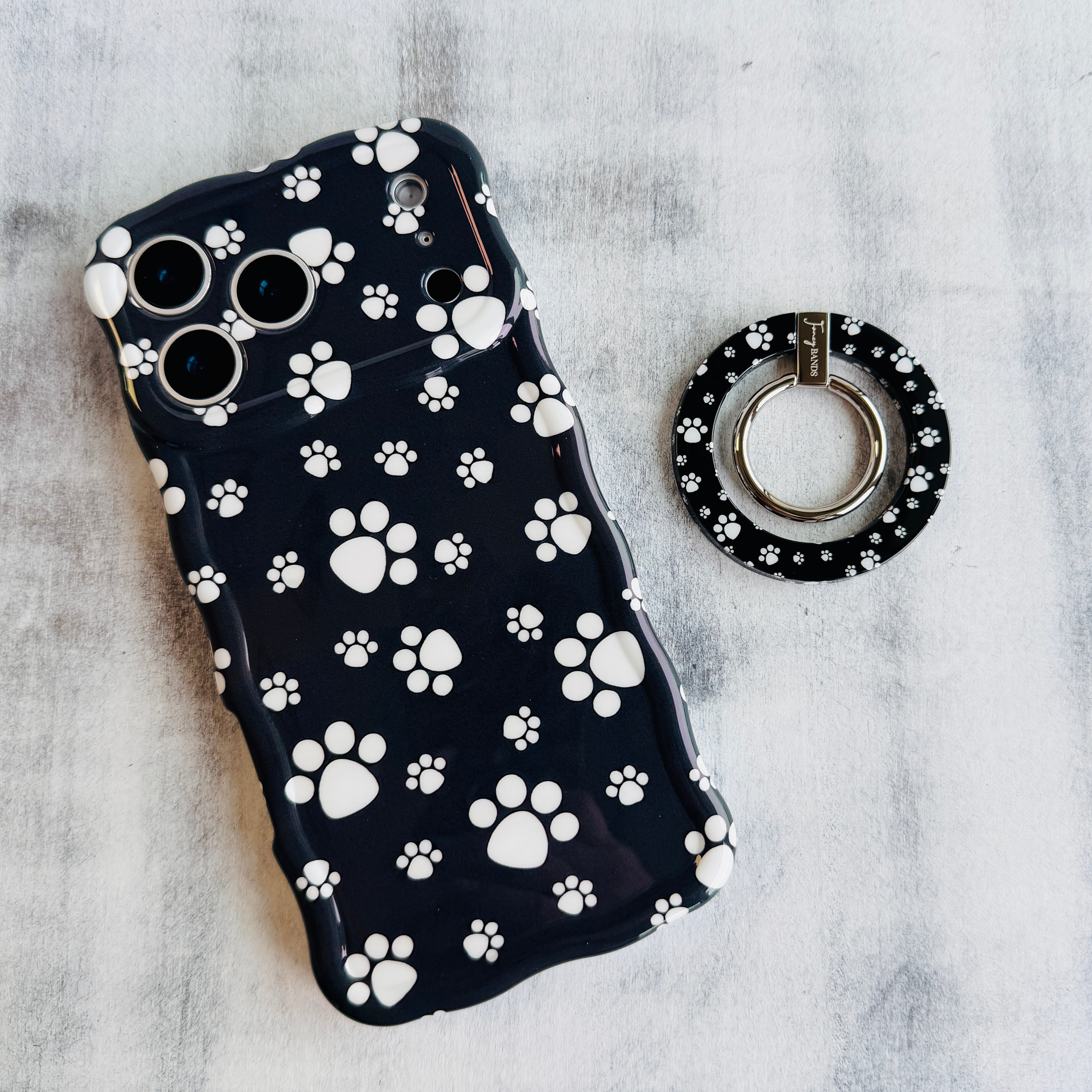 Black Paw Print pattern MagSafe phone grip ring with white paws on black background compatible with iPhone and Samsung