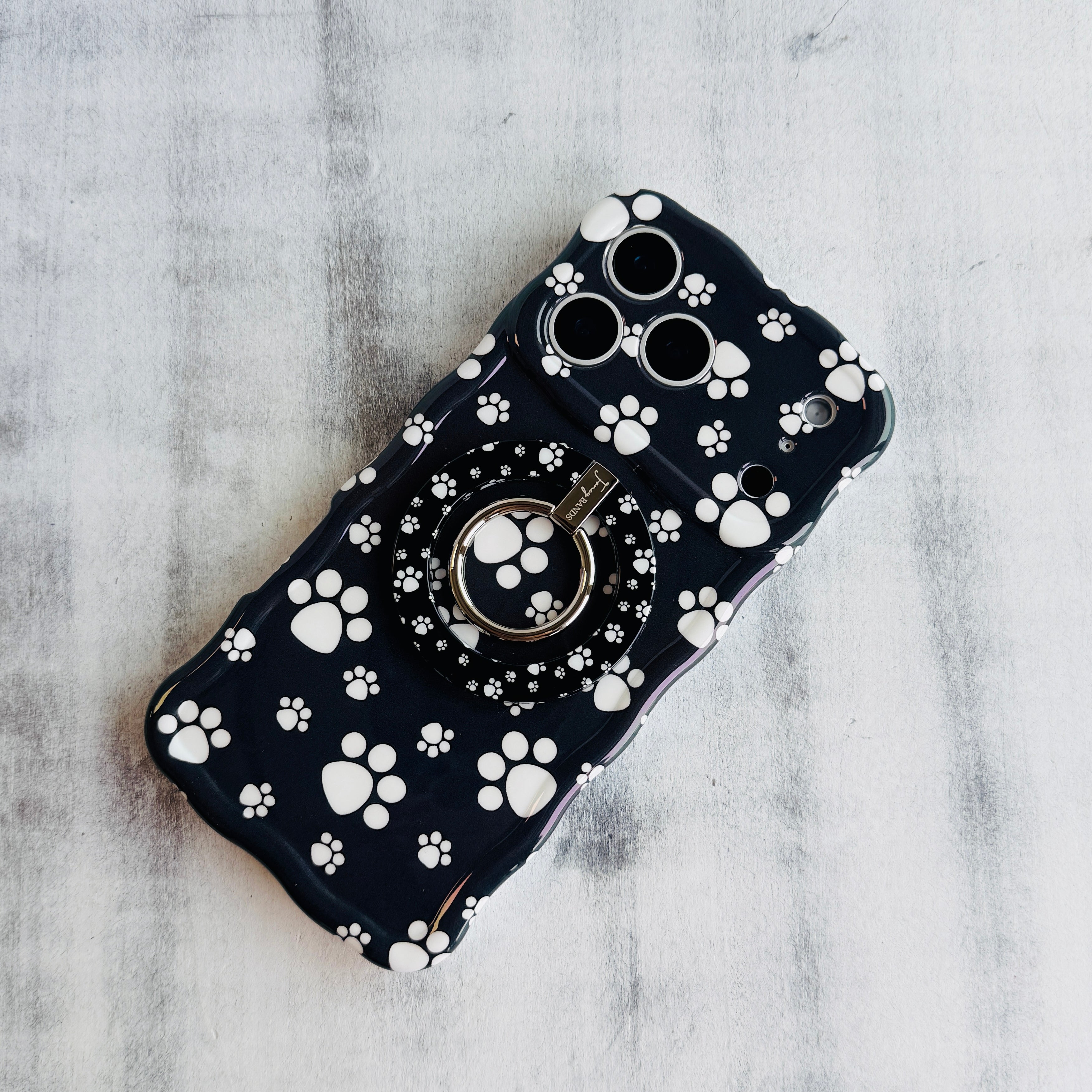 Black Paw Print pattern MagSafe phone grip ring with white paws on black background compatible with iPhone and Samsung
