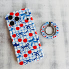 Cherry On Top pattern MagSafe phone grip ring with red cherries blue bows and gingham background compatible with iPhone and Samsung
