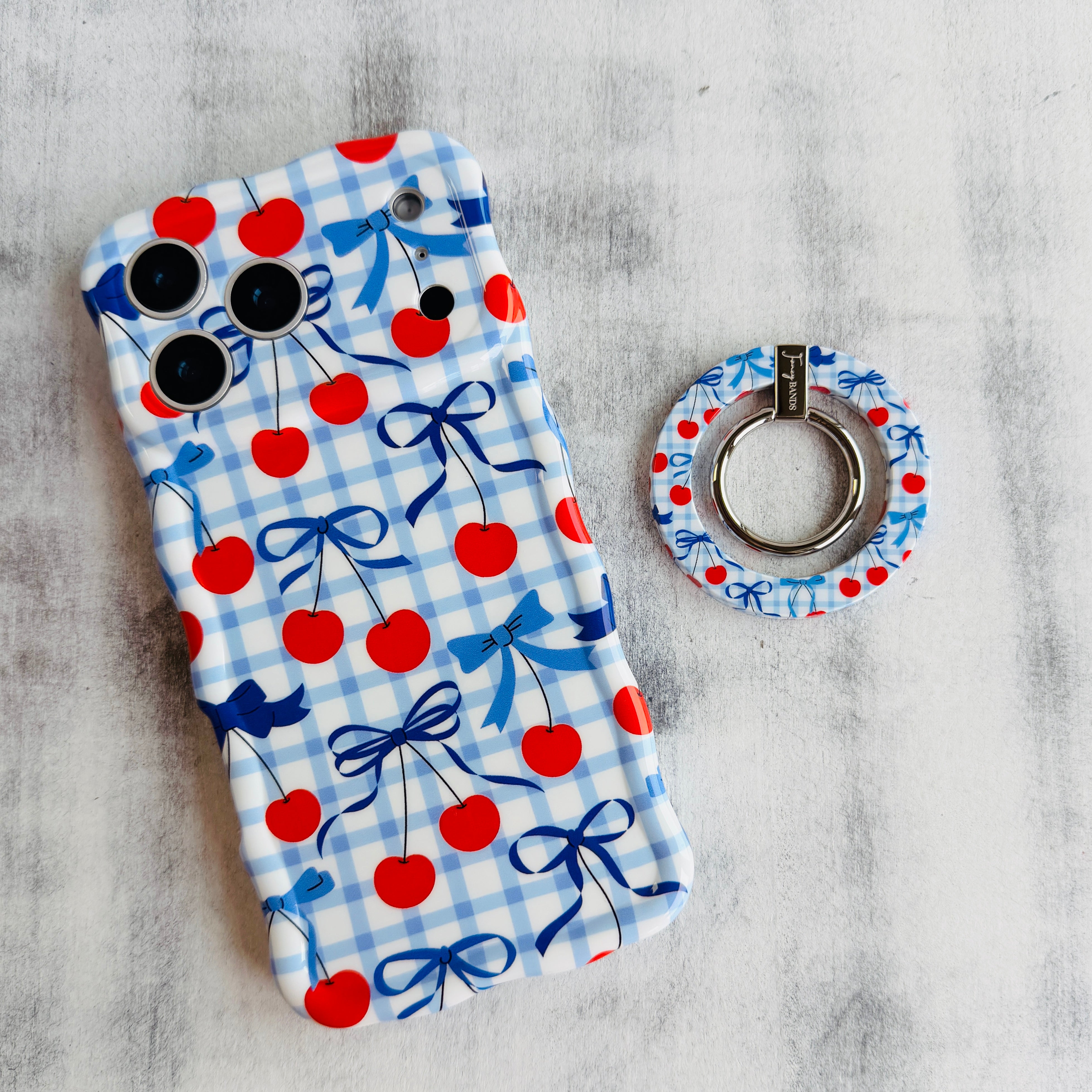 Cherry On Top pattern MagSafe phone grip ring with red cherries blue bows and gingham background compatible with iPhone and Samsung