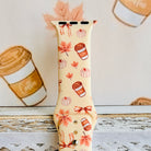 Close view of the Falling in Love a Latte Apple Watch band showing the rust bows, blush maple leaves and pale pumpkins on cream silicone.