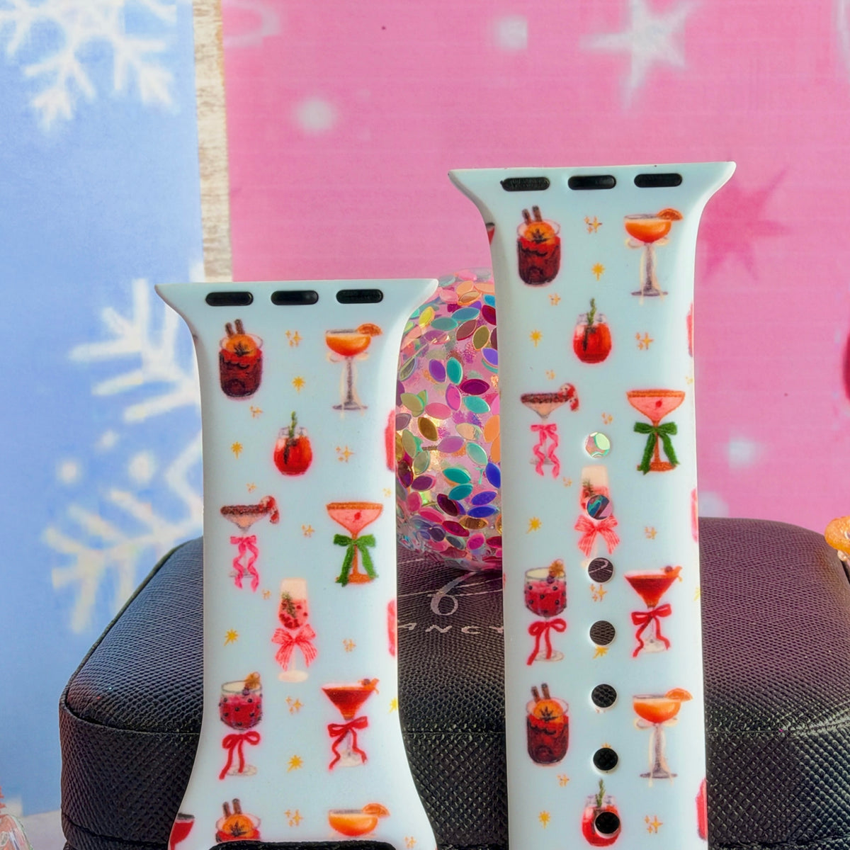 Close-up of both Holiday Spirits, Please? Apple Watch band straps with watercolor holiday cocktails and ribbon bows