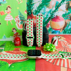 Tinsel & Stardust Apple Watch band on a rose gold Apple Watch and as two straps on a black jewelry box, red and green starbursts on cream