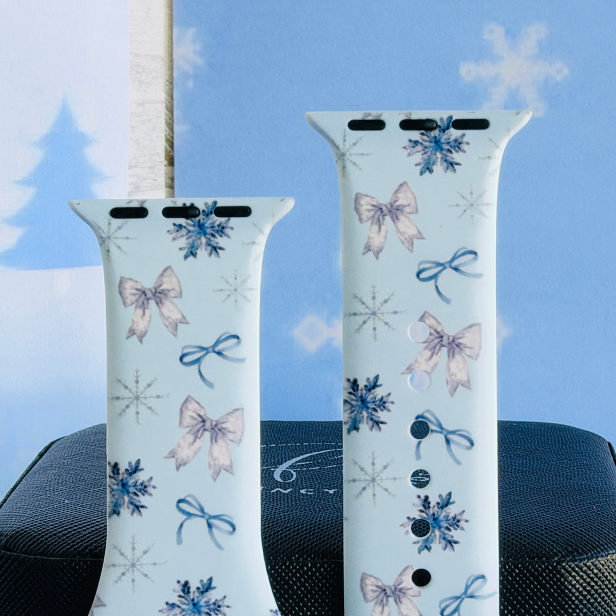 Close-up of both Snow Pretty In Blue Apple Watch band straps with silvery satin bows, blue ribbon bows and snowflakes
