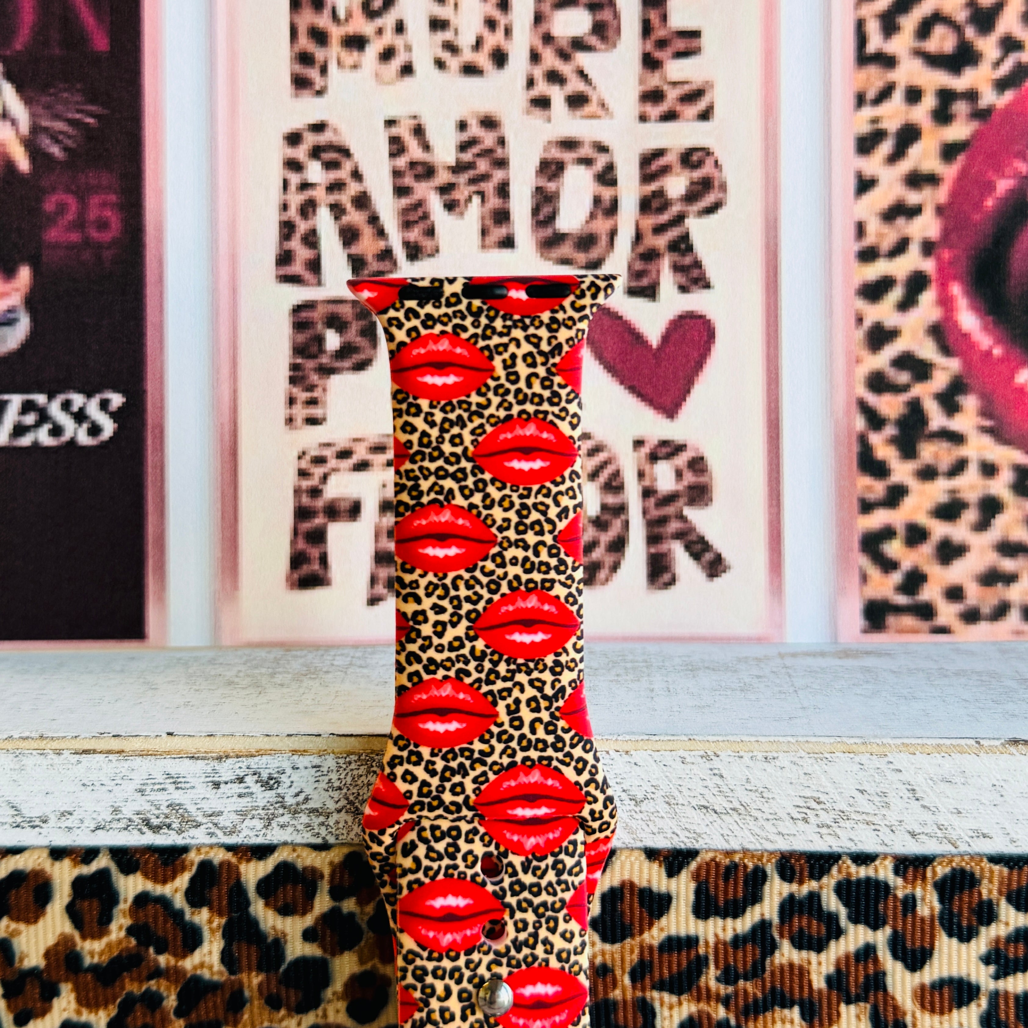 Kiss Me Leopard Apple Watch band with red glossy lips on tan leopard print styled with beauty and fashion decor
