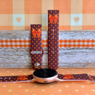 Spotted Looking Cute silicone Samsung Galaxy Watch band shown with a round Galaxy Watch, both strap halves standing upright to display the chocolate brown base, pumpkin-orange polka dots, and orange bow.