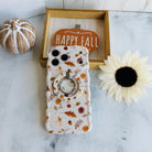 Fall Floral Bliss MagSafe grip ring attached to the matching Fall Floral Bliss iPhone case, styled with a twine pumpkin, a Happy Fall wood sign, and a cream sunflower.