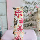 Close-up of a single Champagne Snowfall Apple Watch band strap, pink snowflake print