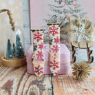 Both Champagne Snowfall Apple Watch band straps on a pink jewelry box with a cloche of bottle-brush trees and a snowy pine backdrop