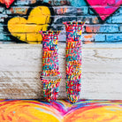 Love Riot Apple Watch band with colorful graffiti "LOVE" text in red, pink, yellow, blue, and turquoise with street art backdrop
