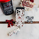 Deer Joy iPhone case with its white snowflake scrunchie wrist strap beside a Most Wonderful Time of the Year tin and a Believe sign