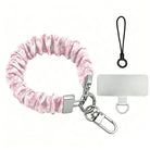 Blush Manor Scrunchie Phone Wrist Strap shown with its silver lobster clasp, black loop cord and phone attachment tab, gathered pink toile fabric.