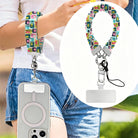 Mod Mood Scrunchie Phone Wrist Strap worn on the wrist with the phone at the hip, plus a close-up of the retro geometric print and metal clasp.