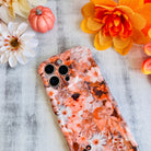 Fall Blooms Wavy Luxe MagSafe iPhone case with a warm autumn floral print in orange and cream, styled with fall decor