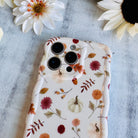 Fall Floral Bliss Wavy Luxe MagSafe iPhone case with watercolor mums, oak leaves, mini pumpkins and acorns on cream, styled with fall decor